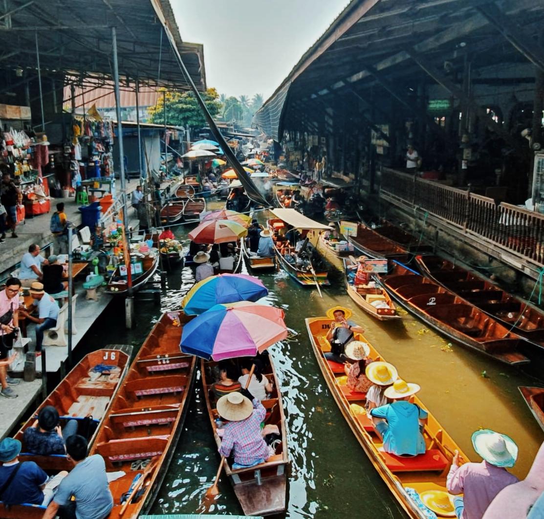 Mercato galleggiante in Thailandia: barche colorate, venditori e turisti. Esperienza culturale unica.